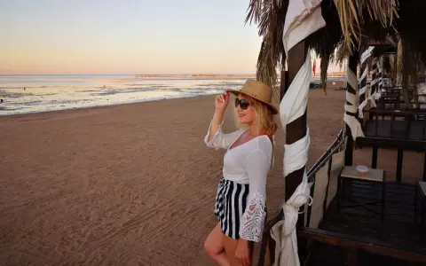 Kobieta w kapeluszu i okularach przeciwsłonecznych na plaży w Hurghadzie. Czy w Hurghadzie jest bezpiecznie? Tak, wygląda na to, że tak!