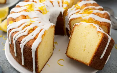 Szybka babka wilgotna, polana lukrem i posypana skórką cytrynową, kusi apetycznym wyglądem.