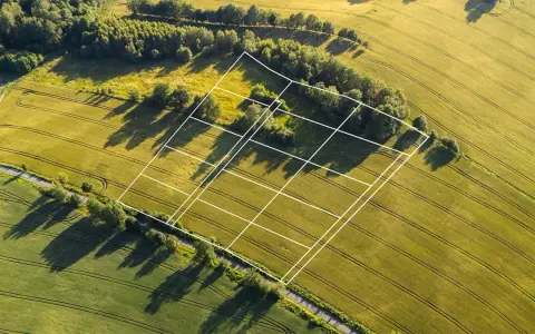 Działki rolne podzielone białymi liniami, widok z lotu ptaka. Przydatne do przeglądania na **lista geoportali**.