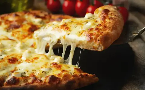 Gorąca pizza z ciągnącym się serem, idealna do pizzy, z pomidorami w tle.
