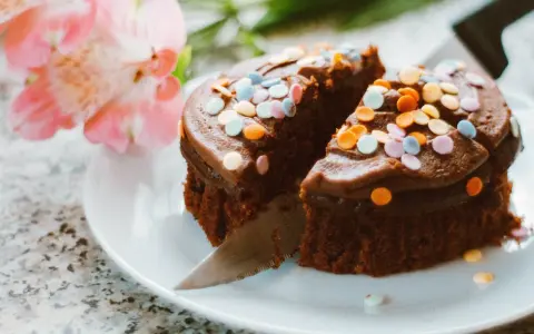 Schokoladenkuchen mit bunten Streuseln, angeschnitten. Eine kreative Idee, um Kuchenreste verwerten und nochmals genießen zu können.