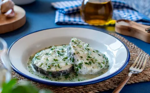 Deliciosa merluza en salsa verde, con perejil fresco picado y un toque de ajo. Un plato clásico y sabroso.