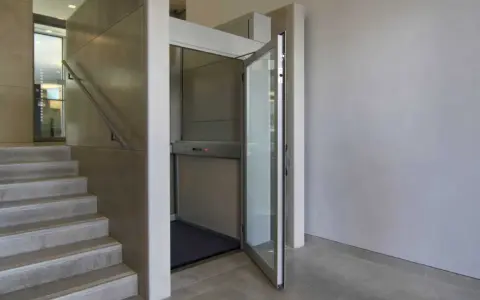 Una piattaforma elevatrice accanto a una scala, una soluzione per chi cerca come abbassare i gradini di una scala, rendendo l'accesso più agevole.