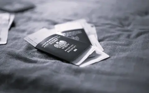 Polskie paszporty leżą na tkaninie, symbolizując długi pobyt w Polsce i plany na pobyt za granicą.