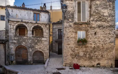 Antico borgo in pietra, con archi e balcone in ferro battuto. La **pretoro altitudine** offre scorci suggestivi tra vicoli acciottolati e case antiche.