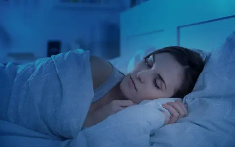 Kobieta w głębokim, spokojnym śnie. Jej twarz jest zrelaksowana, a ciało otulone kołdrą. To idealny senaxa.