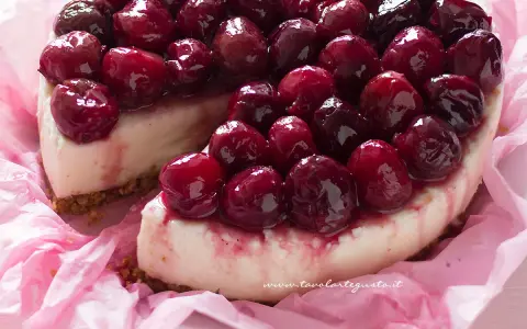 Deliziosa cheesecake alle ciliegie, con una base croccante e una crema vellutata, ricoperta da ciliegie succose e lucide.