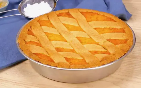 Pastiera napoletana ricetta originale: una torta dorata con decorazione a griglia, pronta per essere gustata.