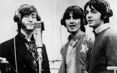 John, George und Paul im Studio, als ob sie back in the USSR wären, mit Kopfhörern und Mikrofon.