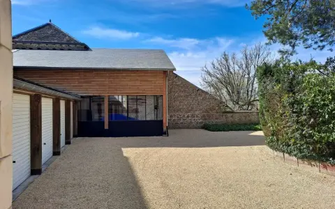 Belle maison tradi pierre Saint Junien avec garage, jardin et ciel bleu.