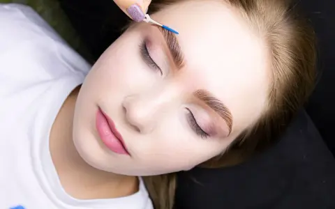 Krok po kroku laminacja brwi w domu. Delikatny pędzelek układa włoski, nadając im perfekcyjny kształt.