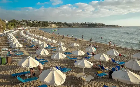 Piękna plaża na Cyprze, gdzie cypr pogoda w listopadzie pozwala na relaks pod białymi parasolami.