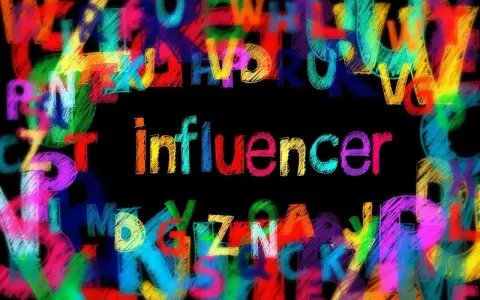Kolorowe litery tworzą tło dla napisu "influencer". To jak zeamsone 5 influencerek tekst, pełen barw i przekazu.
