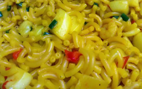 Fideuà con trozos de pimiento rojo y verde, y patata. Una deliciosa fideua receta lista para disfrutar.