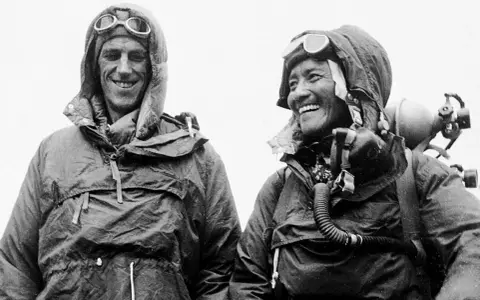 Triumf! Edmund Hillary i Tenzing Norgay po pierwszym zdobyciu Mount Everest. Uśmiechnięci zdobywcy w sprzęcie tlenowym.