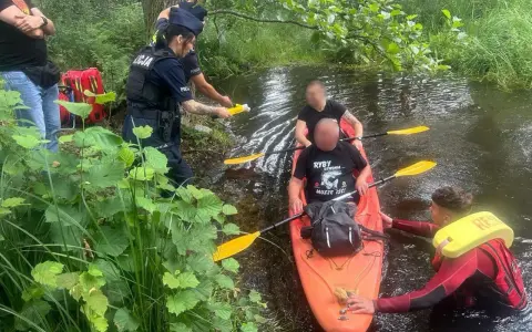 Policja przeprowadza rutynową kontrolę trzeźwości kajakarzy na rzece. Jeden z funkcjonariuszy używa alkomatu.