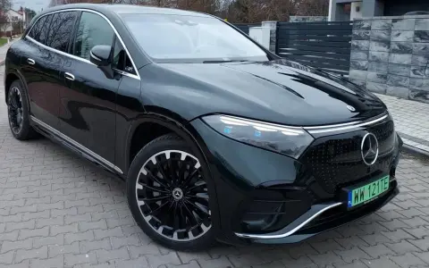 Elegancki, ciemnozielony Mercedes EQS SUV z nowoczesnymi światłami i felgami stoi na podjeździe.