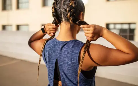 Frauen flechten Boxer Braids für ein sportliches Outfit.