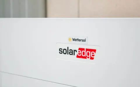En vit enhet med logotyper för Wetter sol och solaredge optimerare.