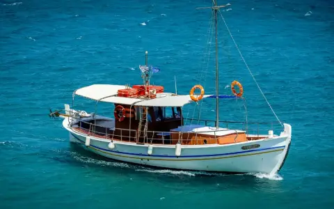 Bateau blanc naviguant sur mer bleue. Le test VHF marine est en cours, tout est prêt pour la traversée.