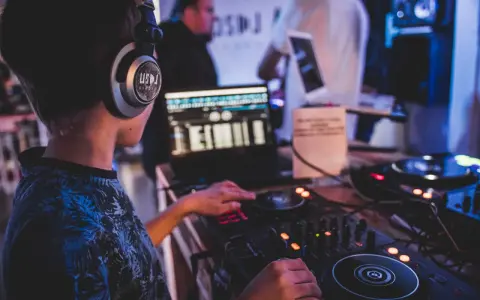 Młody DJ ćwiczy na sprzęcie, słuchawki na uszach. To świetny moment na rozpoczęcie kursu DJ online i naukę miksowania.
