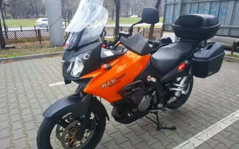 Pomarańczowy motocykl turystyczny Kawasaki KLV 1000 z kuframi, gotowy na przygodę.