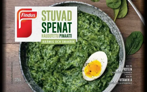 En skål med krämig stuvad spenat, toppad med ett halvt kokt ägg. Findus logotyp syns tydligt.