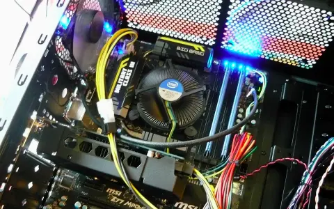 Wnętrze komputera z podświetlaną płytą główną MSI i wentylatorem Intel. Pokazuje, jak działa komputer, z widocznymi kablami i elementami.