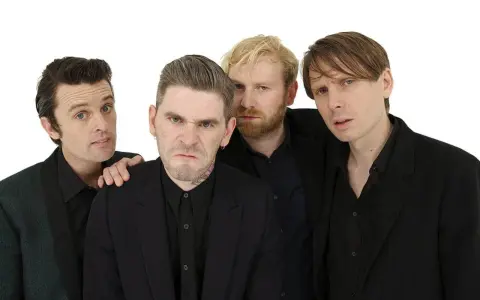 Les membres de Franz Ferdinand posent ensemble, quatre hommes aux regards intenses et aux coiffures stylées, prêts à enflammer la scène.