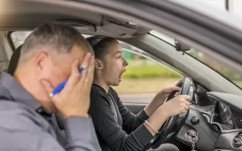 Instructor desesperado mientras una joven conductora, con cara de sorpresa, intenta sacarse el carnet de coche.