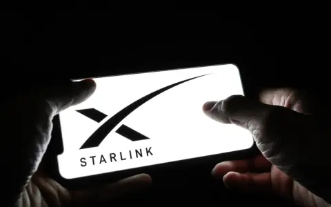 Dłonie trzymają smartfon z logo Starlink. Zainteresowanie **starlink akcje** rośnie.