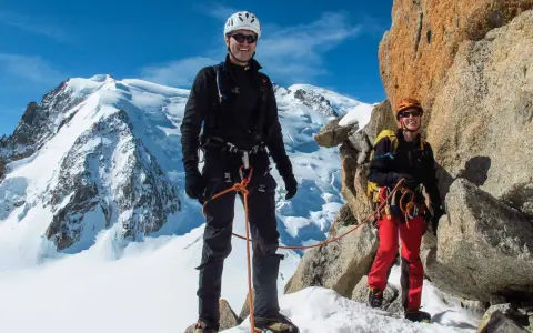Zwei Bergsteiger auf dem Weg zur Mont Blanc Besteigung, umgeben von Schnee und Felsen.