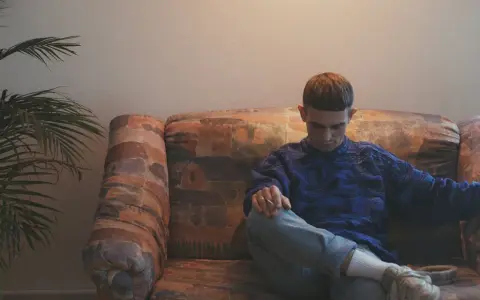 Vito Bambino wpatrzony w dal, siedzi na kanapie. Czyżby myślał o swojej nowej płycie?