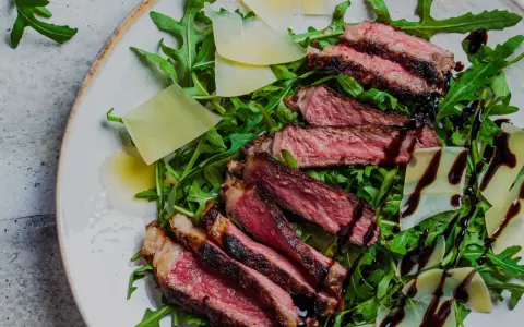 En saftig tagliata på en bädd av rucola med parmesanflisor och balsamico. Ett perfekt tagliata recept för en snabb och lyxig middag.