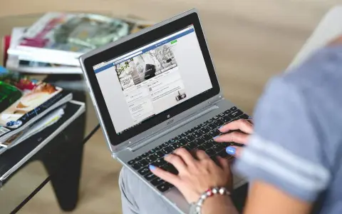 Kobieta pisze na laptopie, przeglądając stronę z inspiracjami wnętrzarskimi. To świetny post powitalny przykład dla nowych użytkowników.