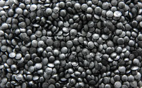 Mnóstwo czarnych granulek regranulatu HDPE, gotowych do przetworzenia w nowe produkty.