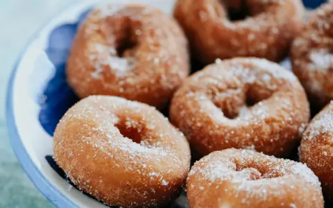 Rosquillas caseras de toda la vida, doradas y espolvoreadas con azúcar, listas para disfrutar.