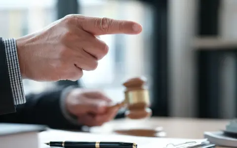 Sędzia wskazuje palcem, młotek sądowy w dłoni. Sprawa dotyczy śmierci wierzyciela a dług.