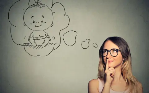 Kobieta w okularach myśli o dziecku. Czy wada wzroku a poród to powód do obaw?