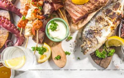 Un'abbondante grigliata di pesce con polpo, gamberi, calamari, aragosta e pesce intero, guarnita con limone e prezzemolo.