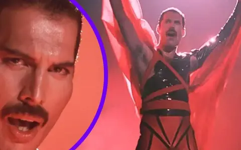 Freddie Mercury w czerwonym stroju, z rękami w górze, promuje swój **freddie mercury solo album**. Obok jego twarz z charakterystycznym wąsem.
