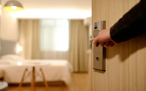 Otwieranie drzwi pokoju hotelowego, by wyłączyć światło i zadbać o oszczędzanie energii.