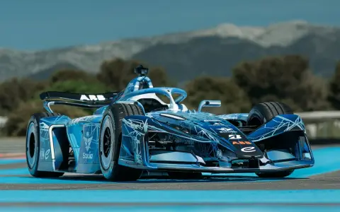 Coche de Fórmula E Gen 4 azul con diseño futurista, listo para la carrera en un día soleado.