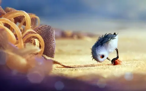 Un pulcino spaventato cerca cibo sulla spiaggia, un'immagine che cattura il significato del cortometraggio "Piper" sulla crescita e il coraggio.