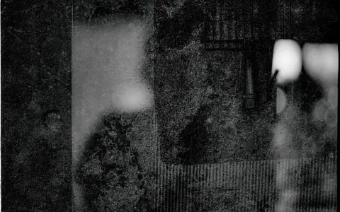 Mroczna, ziarnista fotografia. Widać fragmenty twarzy, być może portret autorstwa Mariusza Gajewskiego, z rozmytymi światłami i teksturami.