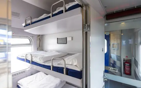 Wygodne łóżka w regiojet wagon sypialny. Trzy piętrowe prycze z pościelą czekają na podróżnych.