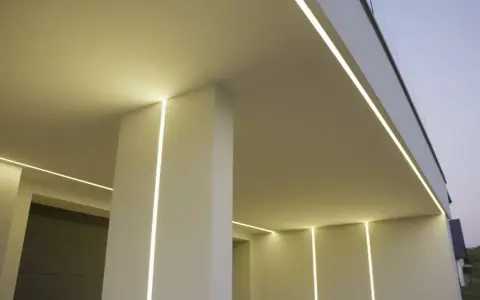 Nowoczesny budynek z subtelnym oświetleniem. Wbudowany profil LED w ścianie tworzy eleganckie linie światła, podkreślając architekturę.
