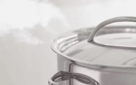 Vapeur s'échappant d'une casserole en inox. Le temps de cuisson du potimarron à l'eau approche de la fin.