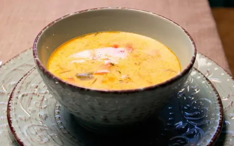 En krämig fisksoppa, perfekt för ett mysigt fisksoppa recept. Serveras i en vacker skål på ett mönstrat fat.