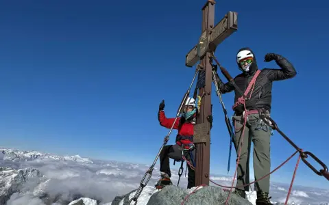 Dwóch alpinistów na szczycie najwyższego szczytu w Austrii, Grossglockner.